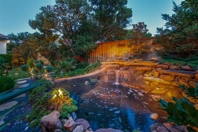 A Koi pond and stacked rock fountain add a special ambiance to the yard. The koi pond offers hours of entertainment watching the many fish dart about. Yet another water feature adds an additional soothing space to the yard. | Image 35