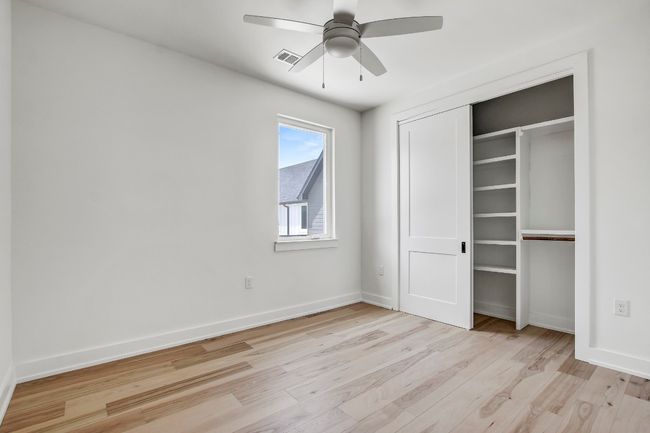 Unfurnished bedroom with light wood-type flooring, baseboards, a closet, and ceiling fan | Image 24