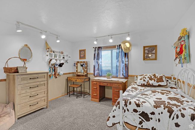 Bedroom with rail lighting, light carpet, and baseboards | Image 30