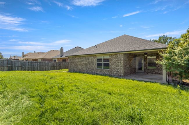 Back of property with a patio, ceiling fan, roof with shingles, and brick siding | Image 34