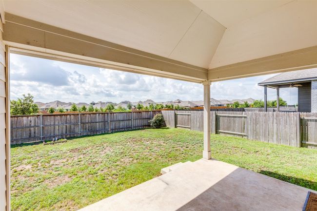 Fenced backyard with a residential view and a patio area | Image 21
