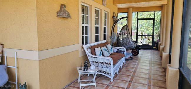 Sunroom with tile patterned flooring and a textured wall | Image 14