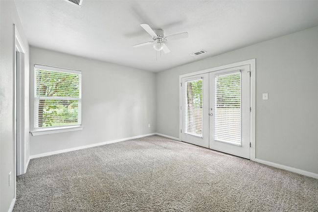 Carpeted empty room with french doors and ceiling fan | Image 11