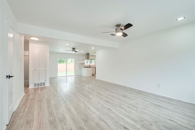 Unfurnished living room featuring ceiling fan, light wood-style flooring, and recessed lighting | Image 6