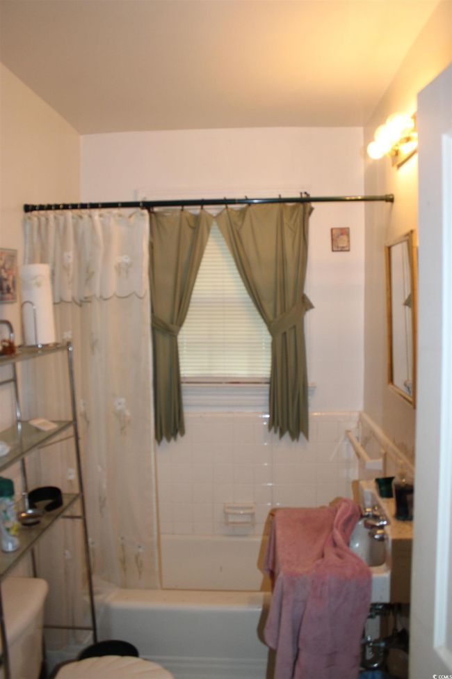 Bathroom featuring toilet, shower / bath combination with curtain, and a sink | Image 16
