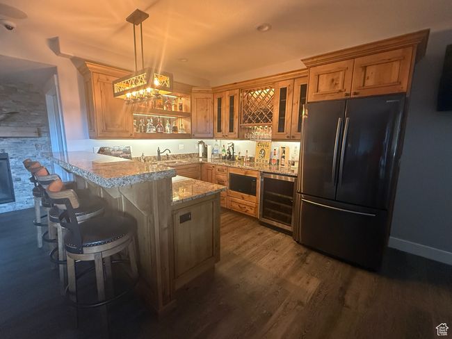 Kitchen with freestanding refrigerator, beverage cooler, a peninsula, built in microwave, and glass insert cabinets | Image 51