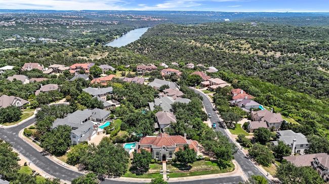 Aerial view of residential area featuring a nearby body of water and a forest | Image 39