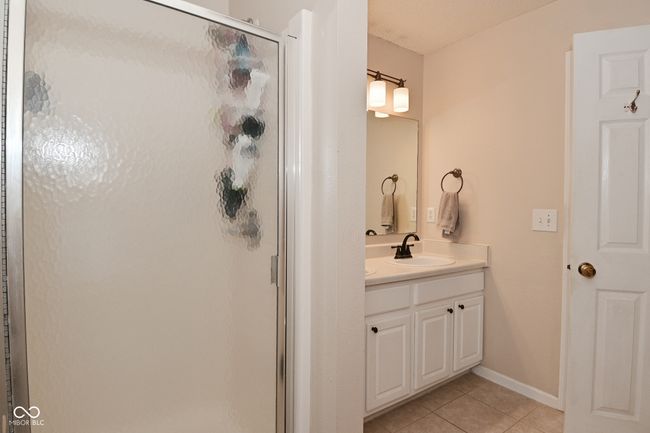 bathroom featuring tile patterned floors, a stall shower, vanity, and baseboards | Image 44