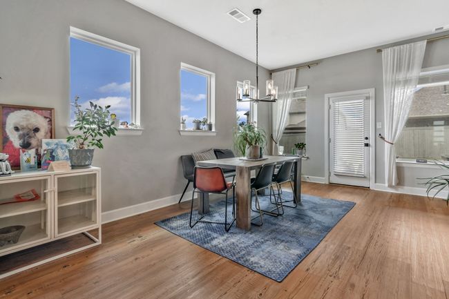 Dining area featuring a chandelier and wood finished floors | Image 15