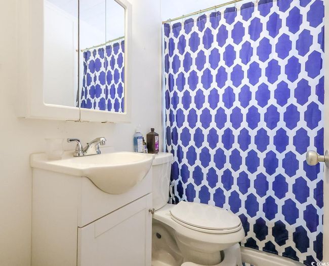 Bathroom featuring toilet, vanity, and a shower with shower curtain | Image 34