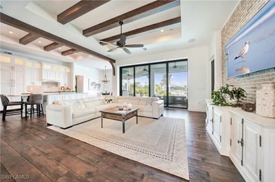 Living room featuring sink, dark wood-look porcelain tile flooring, beam ceiling, and ceiling fan | Image 2