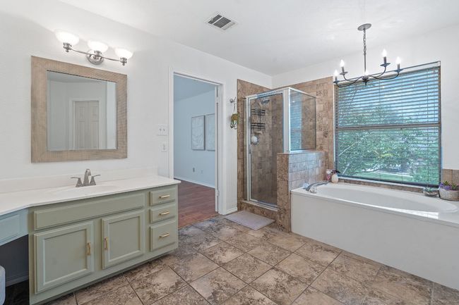 Bathroom featuring a shower stall, a chandelier, a bath, and vanity | Image 22