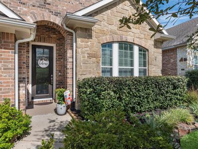 This home features an impressive stone and brick elevation along with meticulously manicured landscaping. | Image 2