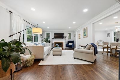 The bright living room features a cozy wood-burning fireplace, recessed lights and opens to the newly renovated kitchen. | Image 2