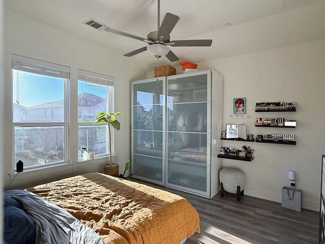 Bedroom featuring a ceiling fan, baseboards, visible vents, and dark wood-type flooring | Image 15