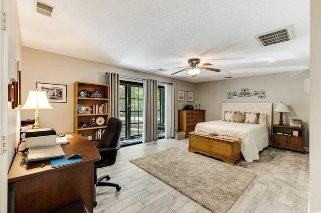 Bedroom with light wood-style floors, visible vents, access to exterior, and a textured ceiling | Image 15