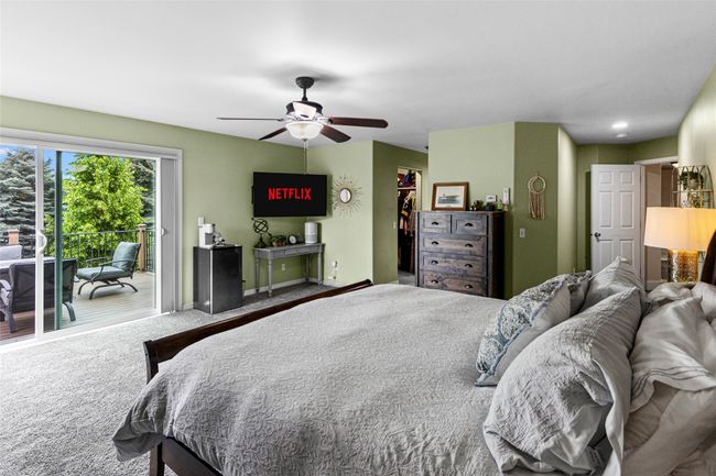 Bedroom with access to outside, carpet floors, a walk in closet, a closet, and ceiling fan | Image 47