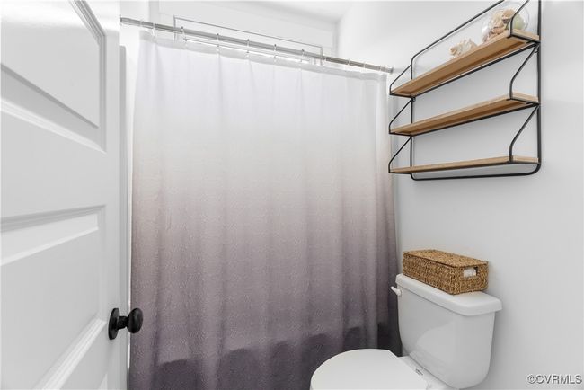 Bathroom featuring toilet and a shower with shower curtain | Image 29