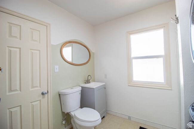 Bathroom featuring toilet, tile patterned floors, vanity, and baseboards | Image 13