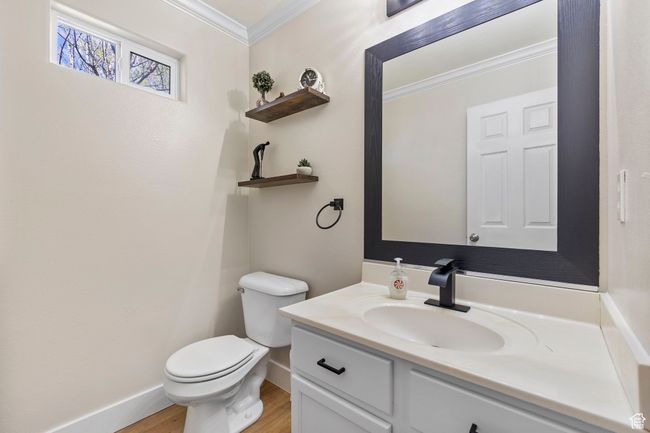 Bathroom featuring wood finished floors, vanity, baseboards, toilet, and ornamental molding | Image 16