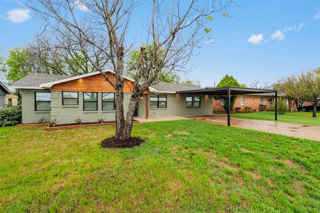 View of front facade with brick siding, a front lawn, concrete driveway, and an attached carport | Image 4