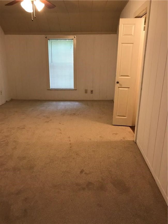 Carpeted empty room featuring a ceiling fan | Image 9