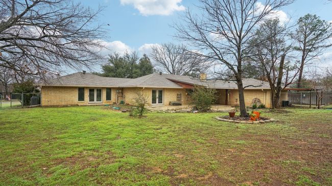 Rear view of house with fence, a chimney, brick siding, and a yard | Image 35