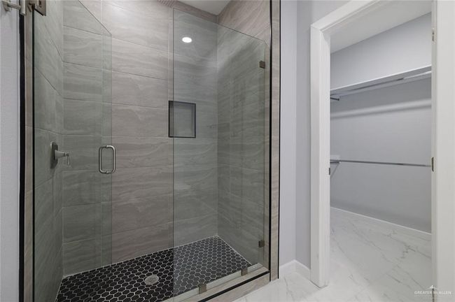 Bathroom featuring baseboards, marble finish floor, a spacious closet, and a shower stall | Image 12