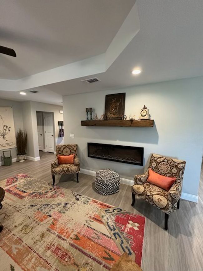Living area with a fireplace, visible vents, baseboards, and wood finished​​‌​​​​‌​​‌‌​‌‌​​​‌‌​​‌‌​‌​​​​​‌ floors | Image 15