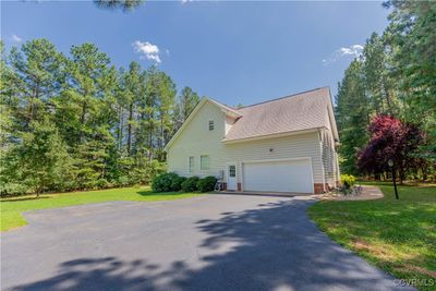 View of side of home with a lawn and a garage | Image 3