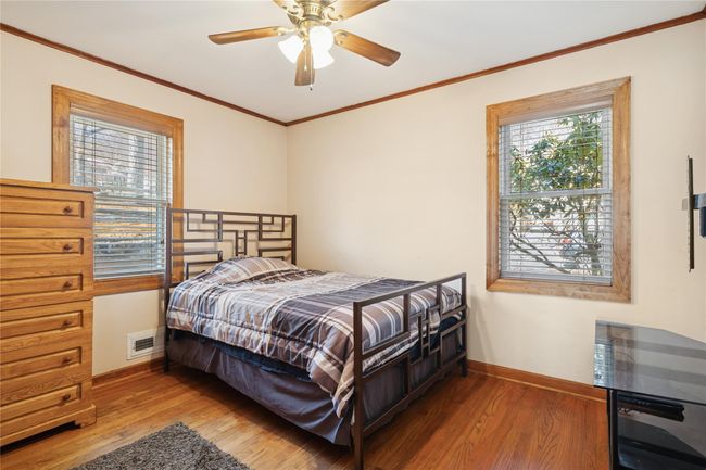 Bedroom featuring visible vents, baseboards, wood finished floors, and ornamental molding | Image 29