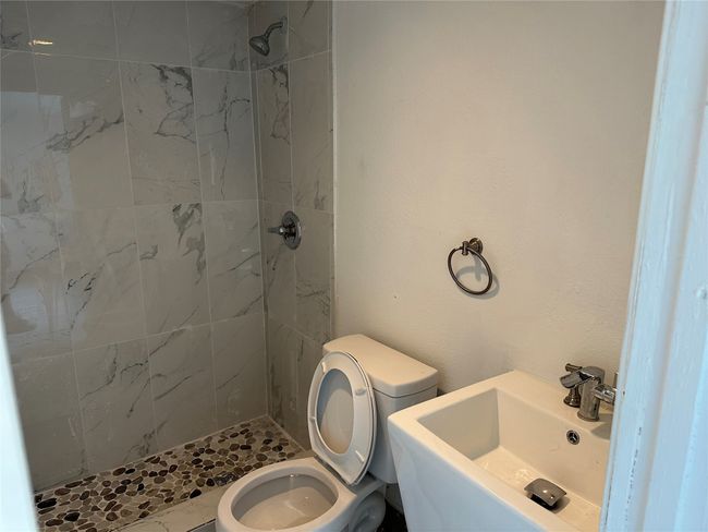 Full bath featuring a shower stall, toilet, and a sink | Image 34