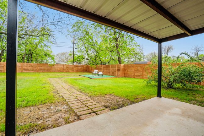 Fenced backyard with a patio | Image 35