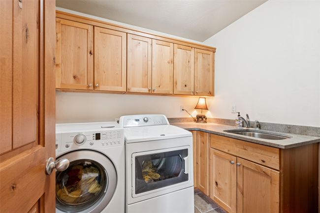 Laundry area featuring washing machine and dryer and cabinet space | Image 39