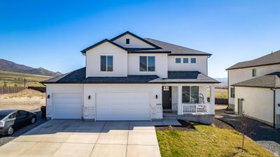 View of front property featuring a mountain view, covered porch, and a garage | Image 1