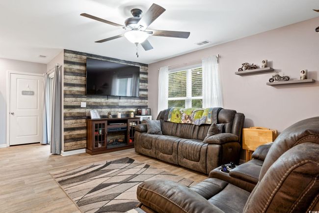 Living room featuring light wood-type flooring and ceiling fan | Image 15