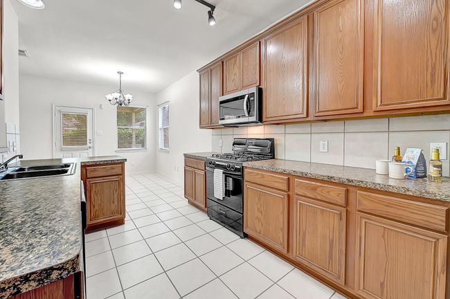 The tiled kitchen features ample cabinetry and counter space for meal-prepping. | Image 7