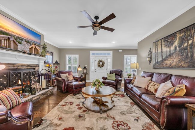 Living room with ceiling fan, wood finished floors, healthy amount of natural light, recessed lighting, and crown molding | Image 12