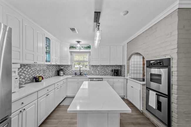 Kitchen featuring white cabinets, a sink, and appliances with stainless steel finishes | Image 14