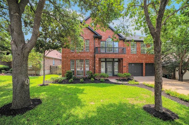 Colonial house featuring concrete driveway, brick siding, a garage, and a balcony | Image 35