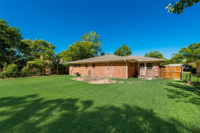 View of yard featuring a fenced backyard, a gate, and a patio | Image 24