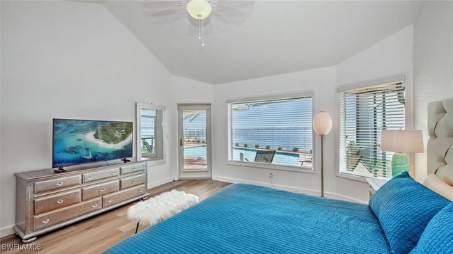 Master Bedroom with access to exterior, light wood-type flooring, multiple windows, ceiling fan, and high vaulted ceiling | Image 17
