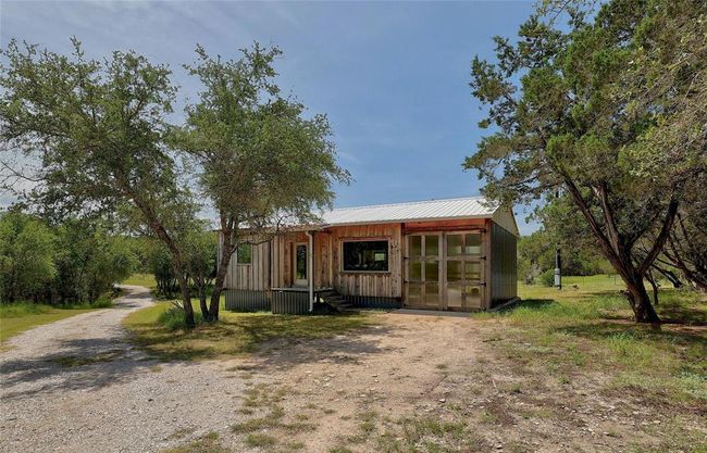 View of front facade featuring driveway and metal roof | Image 24