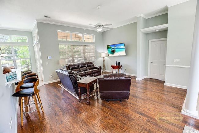 Living area with ornamental molding, a ceiling fan, and wood finished floors | Image 7