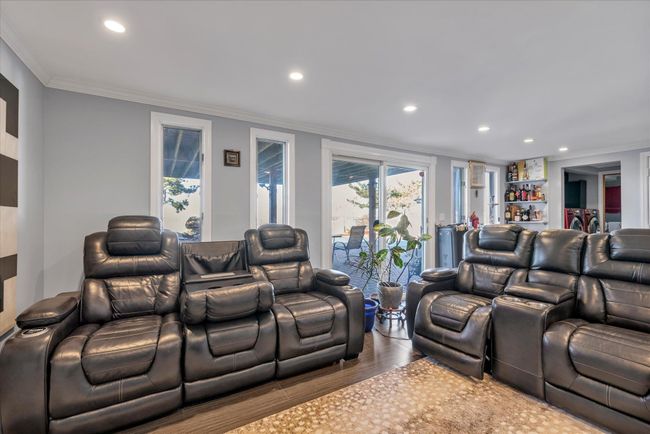 Home theater room with recessed lighting, a bar, crown molding, and wood finished floors | Image 12