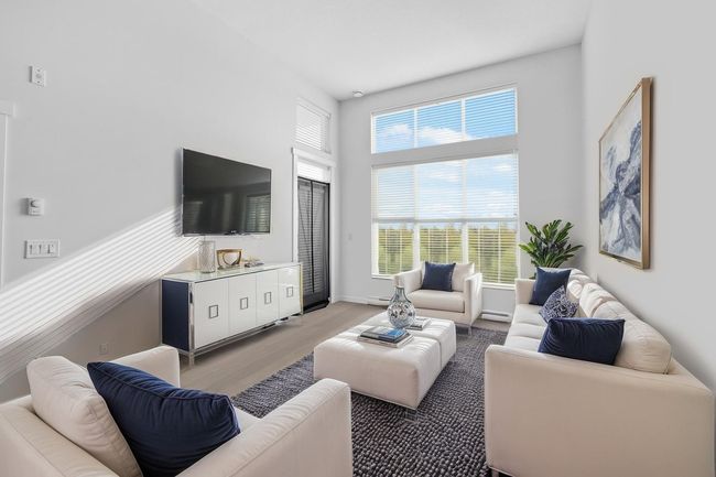 Living area featuring light wood-style flooring and a towering ceiling | Image 5