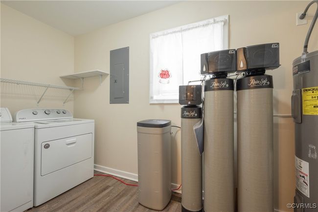 Laundry room with electric panel, water heater, wood finished floors, laundry area, and independent washer and dryer | Image 15