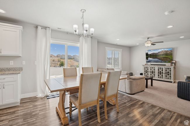 Dining space with dark wood-style flooring, recessed lighting, a chandelier, and ceiling fan | Image 13