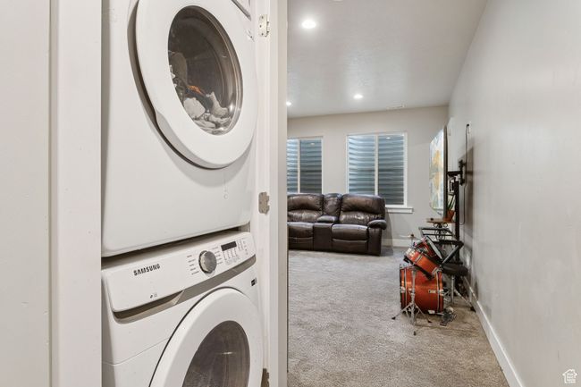 Laundry area with stacked washing machine and dryer, carpet, and recessed lighting | Image 40