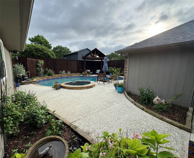 View of swimming pool featuring a gazebo, a fenced backyard, a patio, and a pool with connected hot tub | Image 27